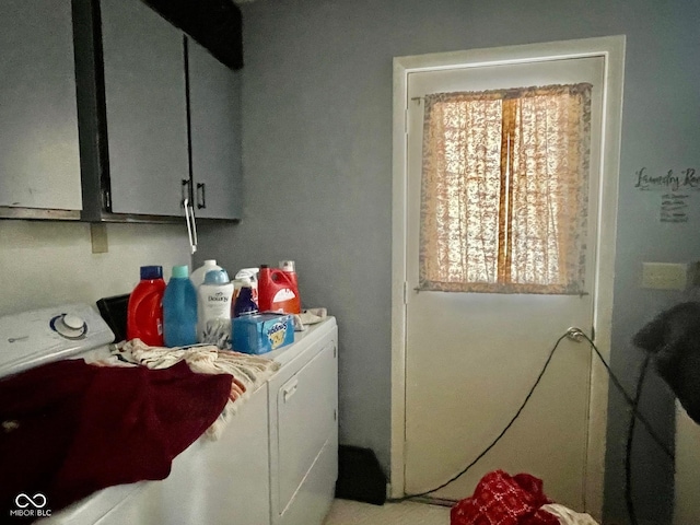 laundry room featuring washer and dryer and cabinets