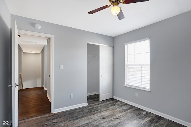 unfurnished bedroom with dark wood-type flooring, ceiling fan, and a closet