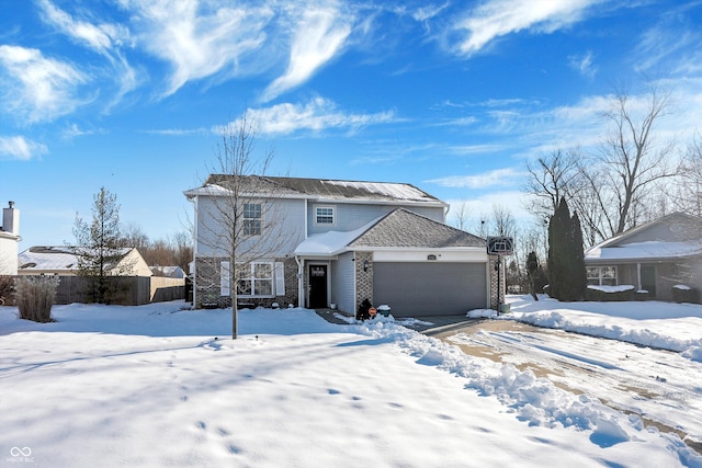 snow covered back of property with a garage