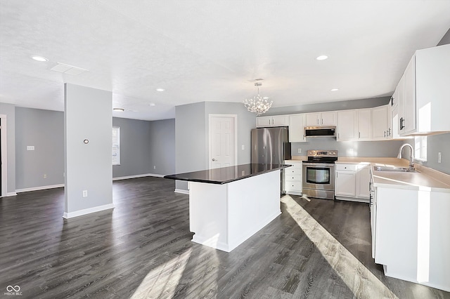 kitchen featuring pendant lighting, white cabinets, a kitchen island, stainless steel appliances, and sink