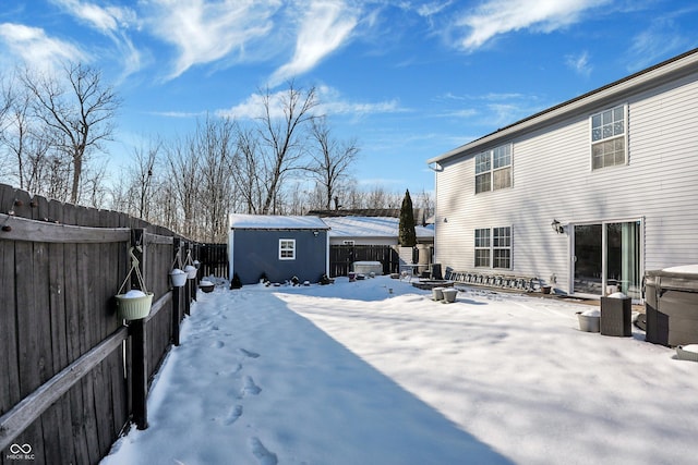 snowy yard featuring a shed