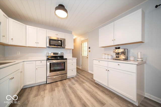 kitchen with light wood-type flooring, appliances with stainless steel finishes, wood ceiling, and white cabinetry