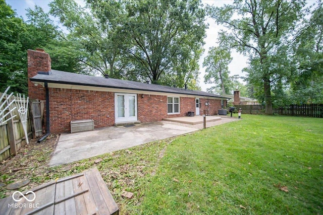 back of house featuring a lawn, french doors, and a patio