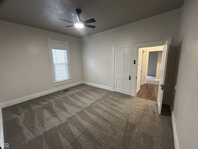 spare room with ceiling fan and carpet