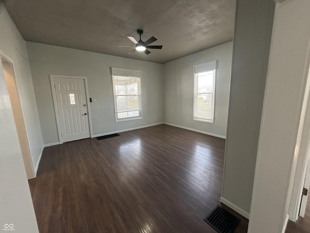 foyer entrance with ceiling fan, plenty of natural light, and dark hardwood / wood-style floors