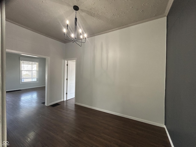 empty room featuring crown molding, dark hardwood / wood-style floors, and a chandelier