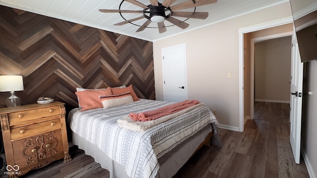 bedroom featuring crown molding, dark wood-type flooring, and ceiling fan