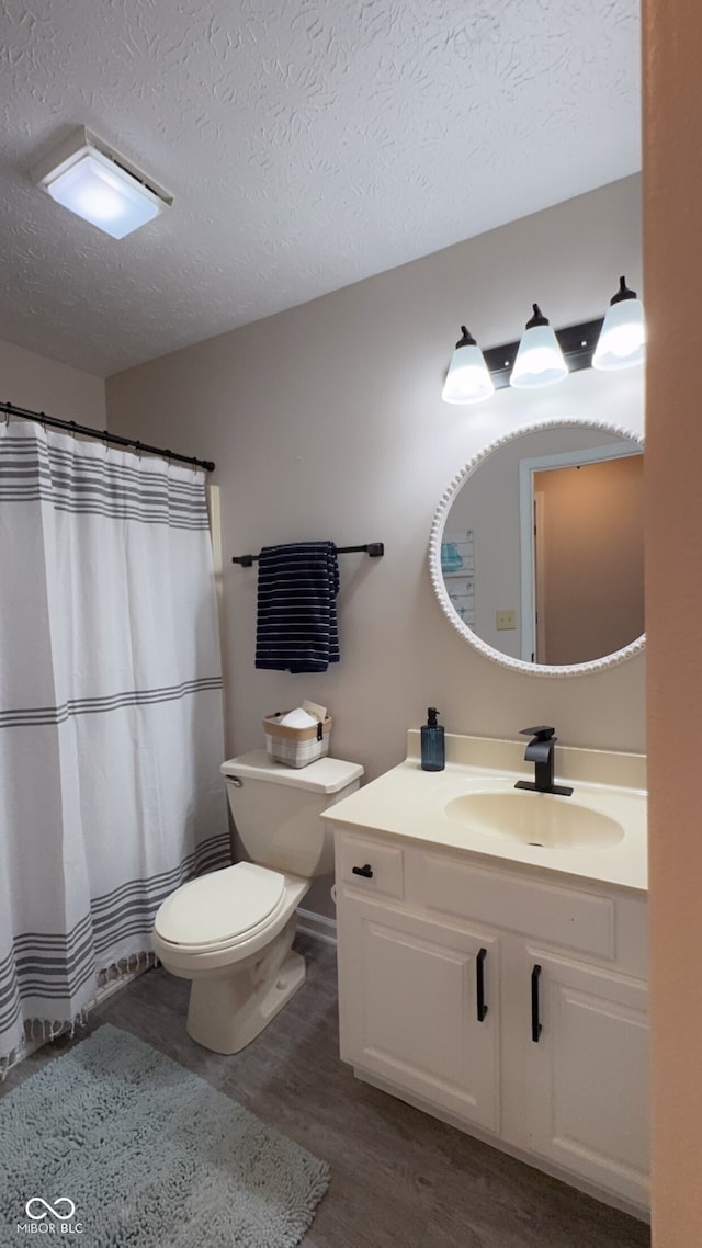 bathroom with vanity, hardwood / wood-style floors, toilet, and a textured ceiling