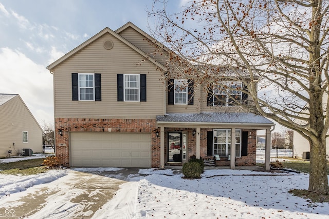 front facade featuring cooling unit, a garage, and covered porch