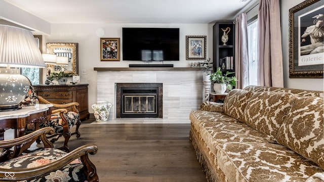 living room featuring a wealth of natural light, dark hardwood / wood-style flooring, and a tile fireplace