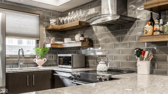 kitchen featuring island exhaust hood, backsplash, stainless steel electric stove, dark brown cabinets, and sink