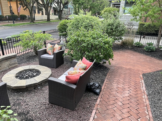 view of patio featuring an outdoor living space with a fire pit and fence