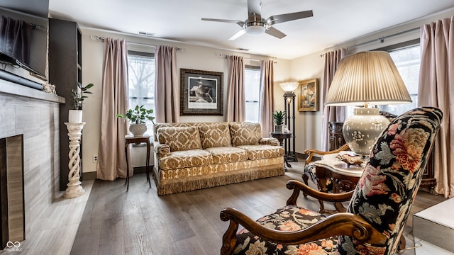 living room featuring a wealth of natural light, a ceiling fan, hardwood / wood-style floors, and a fireplace