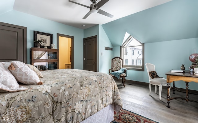 bedroom with visible vents, a ceiling fan, wood finished floors, baseboards, and lofted ceiling