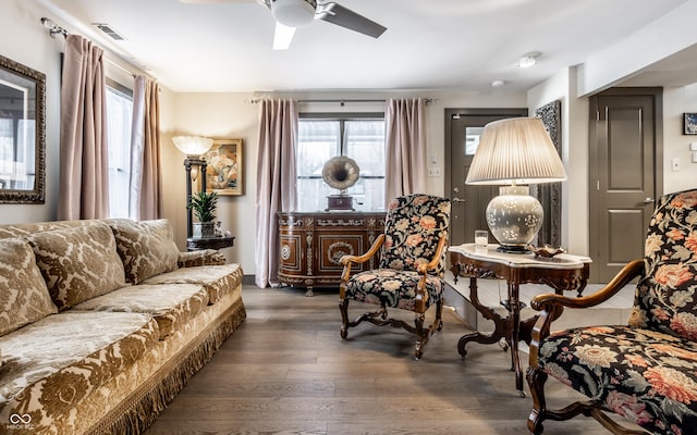 sitting room with a ceiling fan, wood finished floors, and visible vents