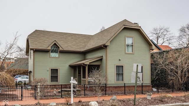 view of front of house with a fenced front yard and roof with shingles