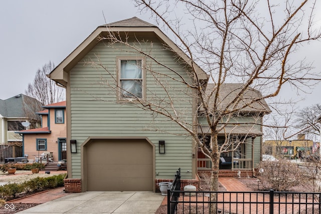 exterior space with a garage, a porch, a fenced front yard, and driveway