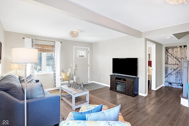 living room with a barn door and dark wood-type flooring