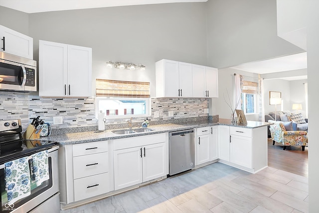 kitchen with white cabinets, appliances with stainless steel finishes, and sink