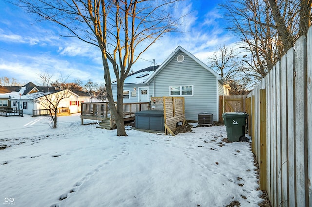 snow covered house featuring a wooden deck and central air condition unit