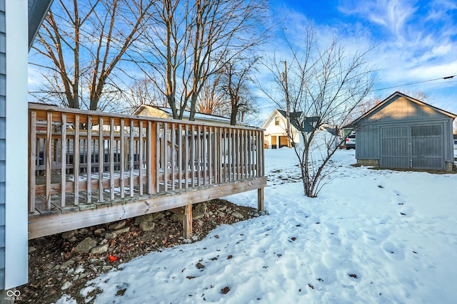 yard covered in snow featuring a wooden deck and a shed