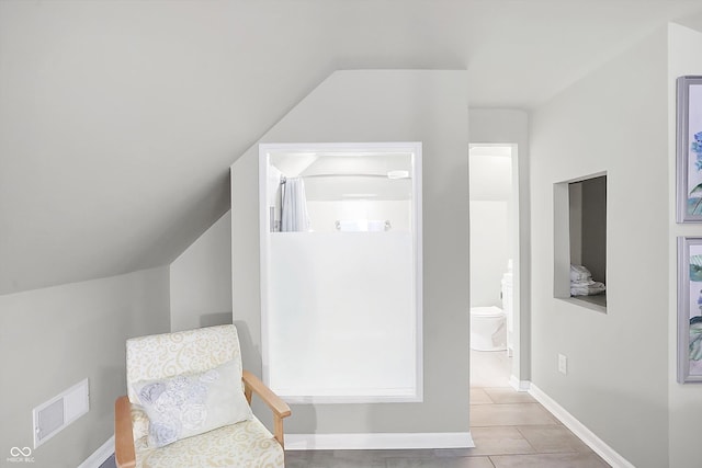 sitting room featuring light tile patterned floors and lofted ceiling