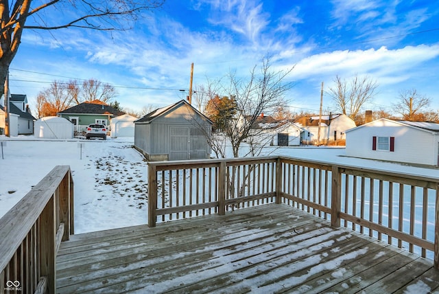 snow covered deck featuring a storage shed