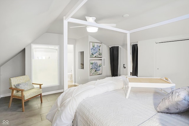 bedroom with ceiling fan, ensuite bathroom, and lofted ceiling