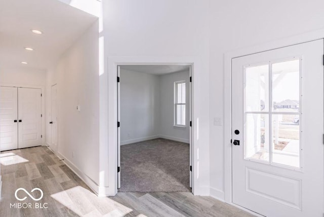 foyer entrance with light wood-type flooring and a healthy amount of sunlight