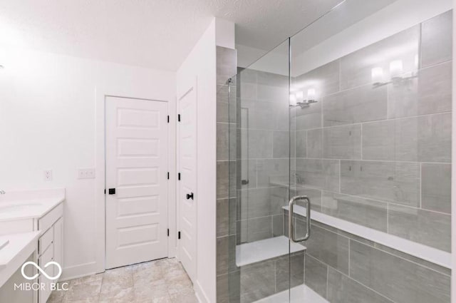 bathroom featuring vanity, a shower with door, and a textured ceiling