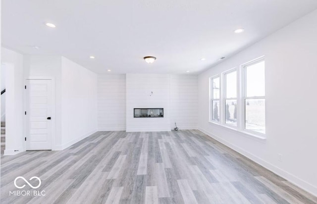 unfurnished living room with a fireplace and light hardwood / wood-style flooring