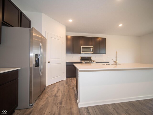 7824 Magnolia St, New Palestine, IN 46163 - kitchen with stainless steel appliances, light countertops, dark wood finished floors, dark brown cabinetry, and a kitchen island with sink