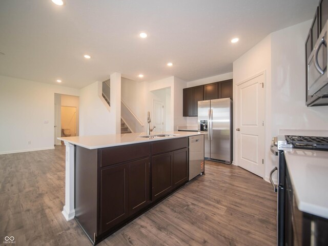 7824 Magnolia St, New Palestine, IN 46163 - kitchen with stainless steel appliances, dark brown cabinets, dark wood-type flooring, a center island with sink, and recessed lighting