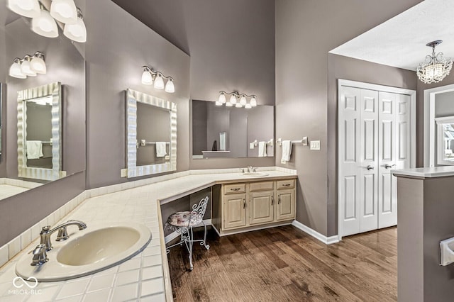 bathroom with vanity, wood-type flooring, and an inviting chandelier