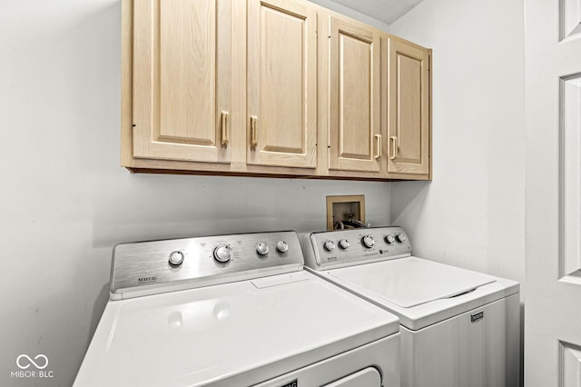 clothes washing area with cabinets and independent washer and dryer