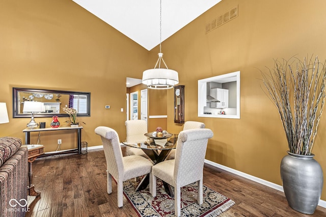 dining space with dark hardwood / wood-style floors and high vaulted ceiling