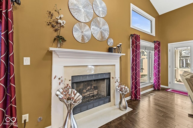 living room with lofted ceiling, hardwood / wood-style flooring, and a premium fireplace