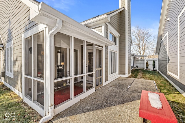 view of home's exterior with a patio and a sunroom