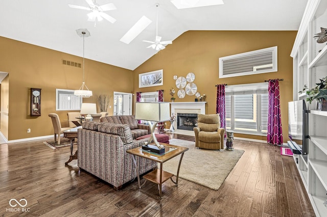 living room with a skylight, high vaulted ceiling, dark hardwood / wood-style floors, and ceiling fan