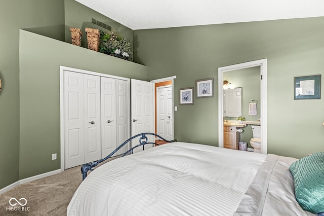 bedroom featuring ensuite bathroom, carpet flooring, and high vaulted ceiling