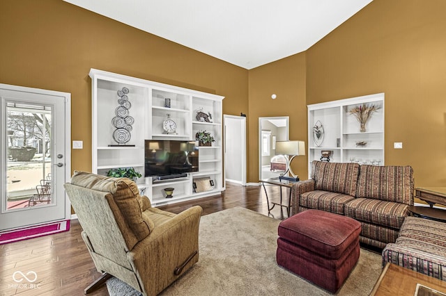 living room with hardwood / wood-style floors and a high ceiling