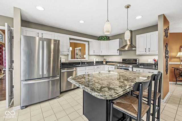 kitchen with light tile patterned flooring, sink, a breakfast bar area, stainless steel appliances, and wall chimney exhaust hood