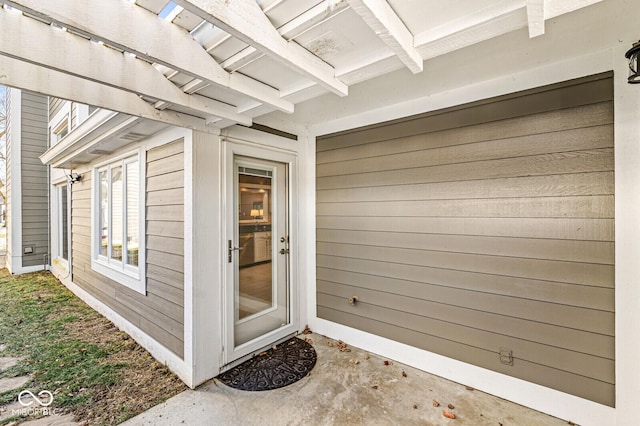 view of exterior entry featuring a patio