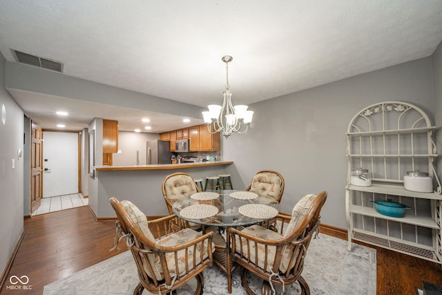 dining space with an inviting chandelier and light wood-type flooring