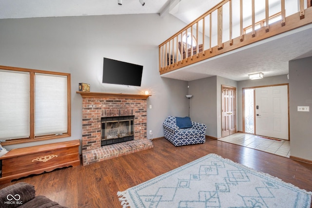 living room featuring wood-type flooring, a fireplace, and vaulted ceiling