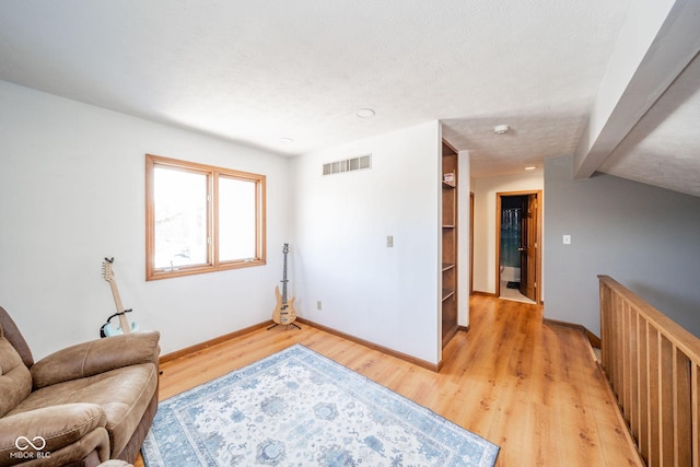 sitting room featuring a textured ceiling and light wood-type flooring