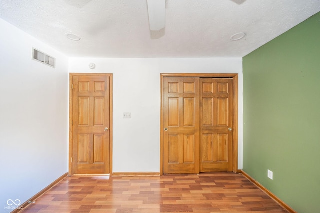 unfurnished bedroom featuring a textured ceiling and light hardwood / wood-style floors