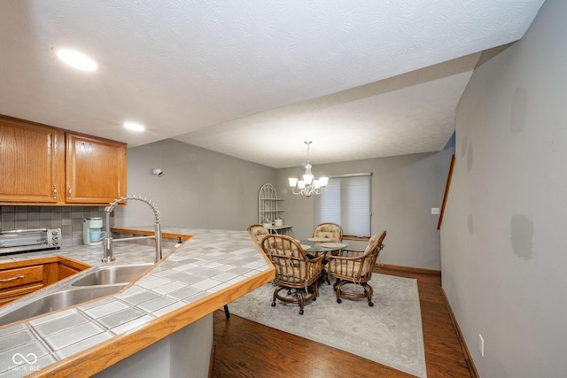 dining area featuring sink, dark hardwood / wood-style floors, and a notable chandelier