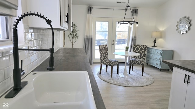 dining room featuring sink, hardwood / wood-style floors, and french doors