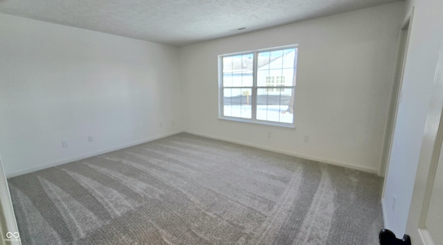 carpeted empty room with a textured ceiling